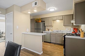 View looking into kitchen with breakfast bar and light brown cabinets